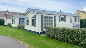Una hilera de casas móviles con techo plano, revestimiento blanco y contraventanas grises.