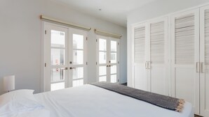 A hotel room with a large bed, white walls, and a wardrobe with sliding doors. - Casa Love by Wynwood House (Panama City)