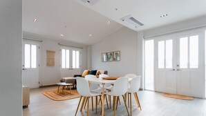 A spacious room with a dining table, chairs, a sofa, and a large window. - Casa Love by Wynwood House (Panama City)