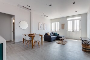 A modern living room with a dining area, a sofa, and a round mirror on the wall. - Casa Love by Wynwood House (Panama City)