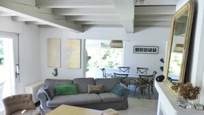 Een woonkamer met een bank, stoelen, een tafel en een open haard.