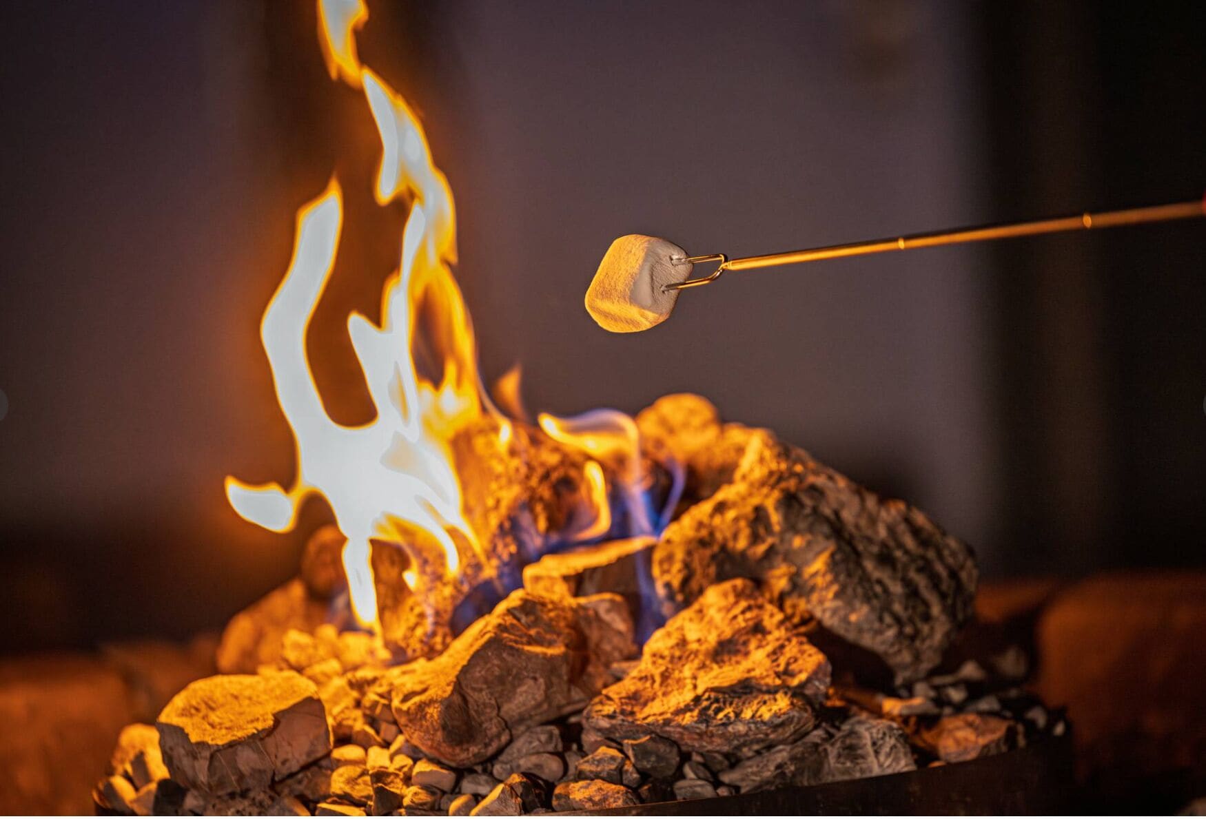 A marshmallow being roasted over a campfire with visible flames.