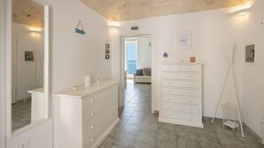 A clean, modern bathroom with a large mirror, a white vanity, and a shower area.