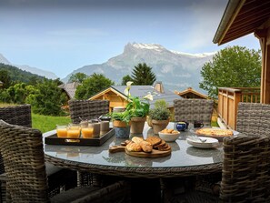 Enjoy a serene mountain dining experience with a beautifully set table amidst breathtaking views.