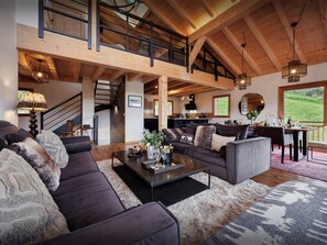 Relax in a spacious living area with a high ceiling, comfortable seating, and a dining space.