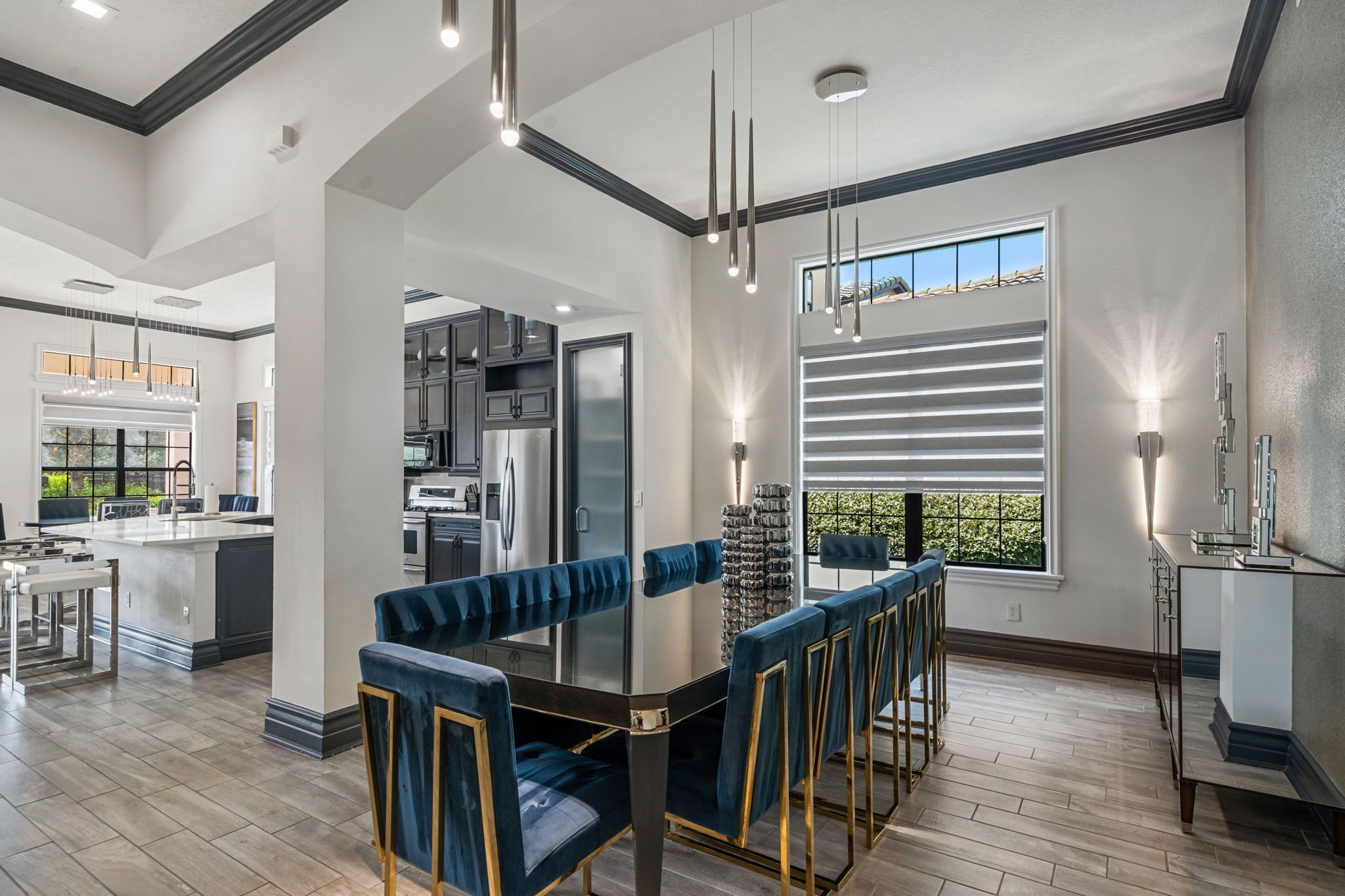 A modern kitchen with a central island, bar seating, and pendant lighting.