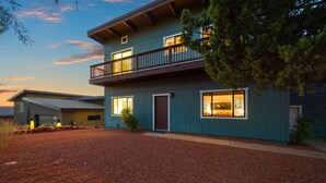 A two-story house with a balcony, a driveway, and a gravel front yard. - Sedona Red Rock Serenity Retreat! (Sedona)