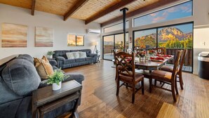 A spacious living area with a wooden ceiling, a dining table set for four, and a large window offering a mountain view. - Sedona Red Rock Serenity Retreat! (Sedona)