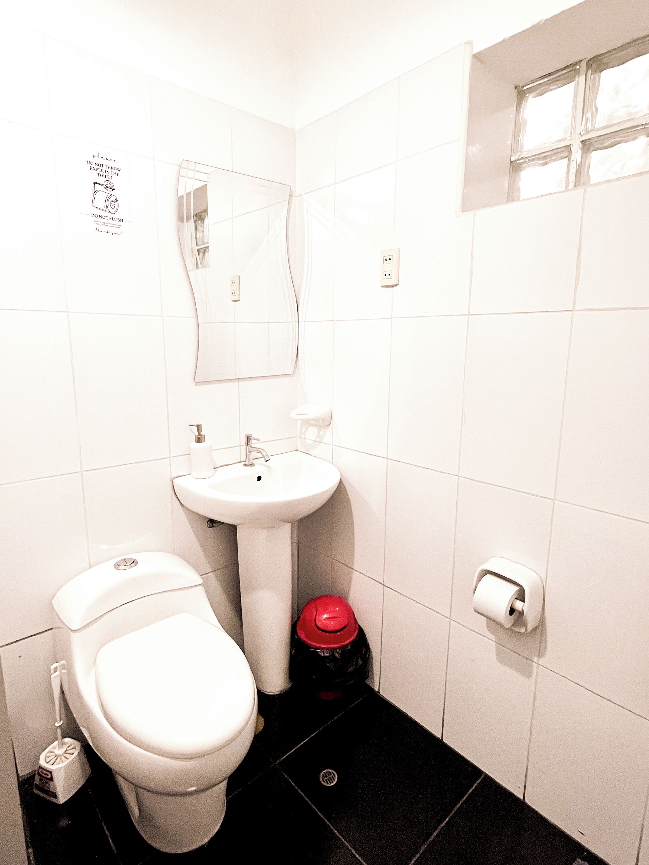 Un bagno piccolo e pulito, con il water, lavandino e specchio.