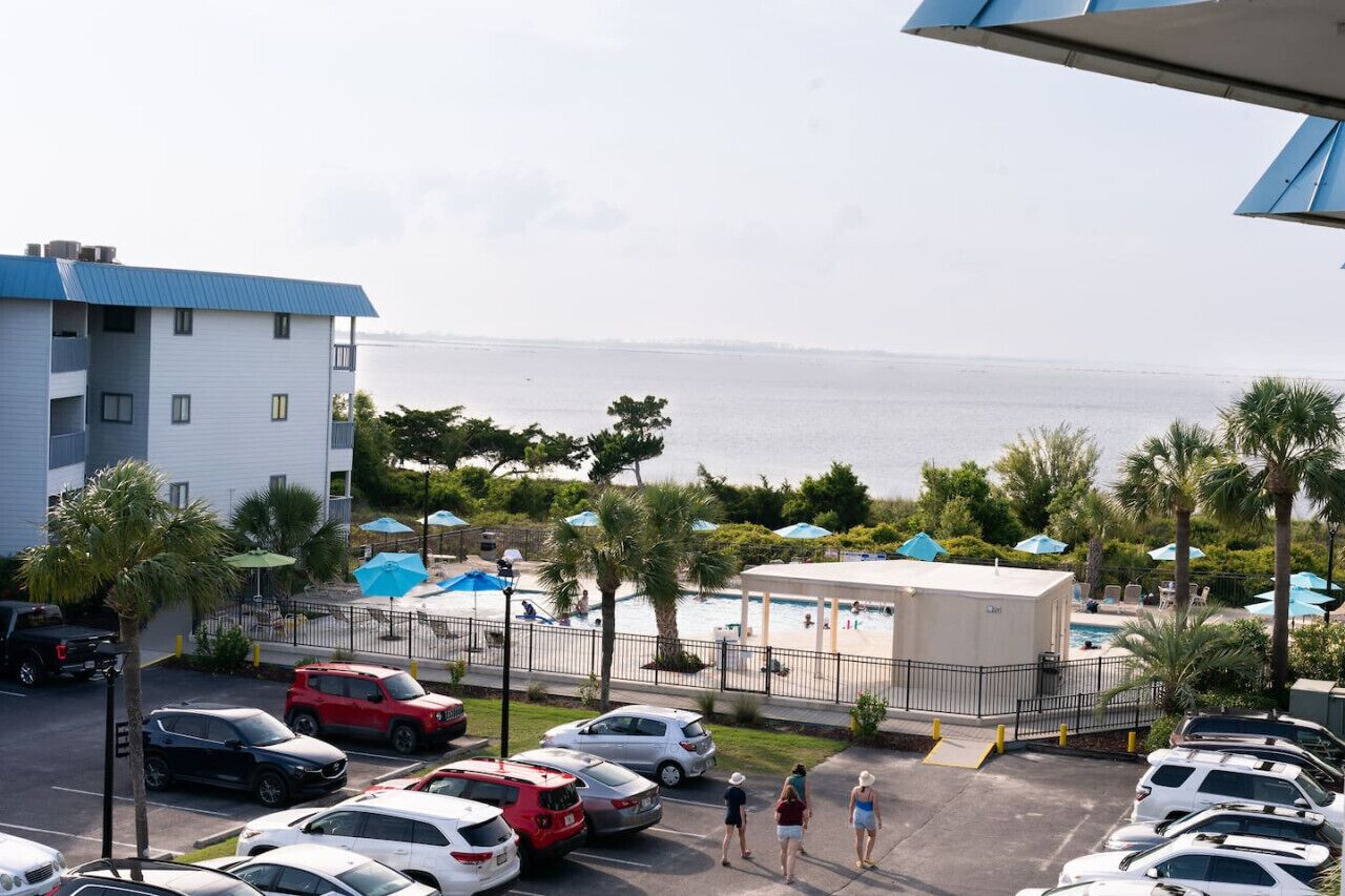 Un hotel con piscina, parcheggio e vista sul mare.