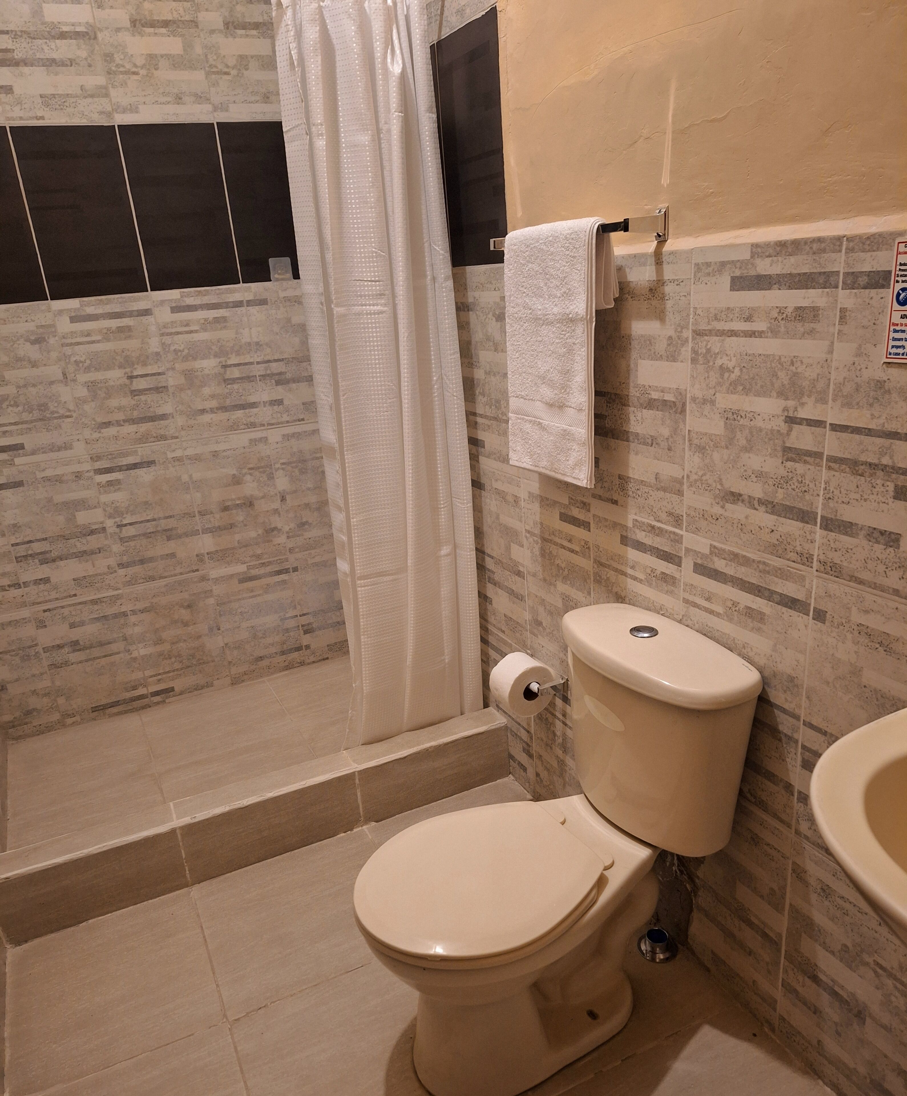 Ein Badezimmer mit Toilette, einer Duschkabine und einem Waschbecken.