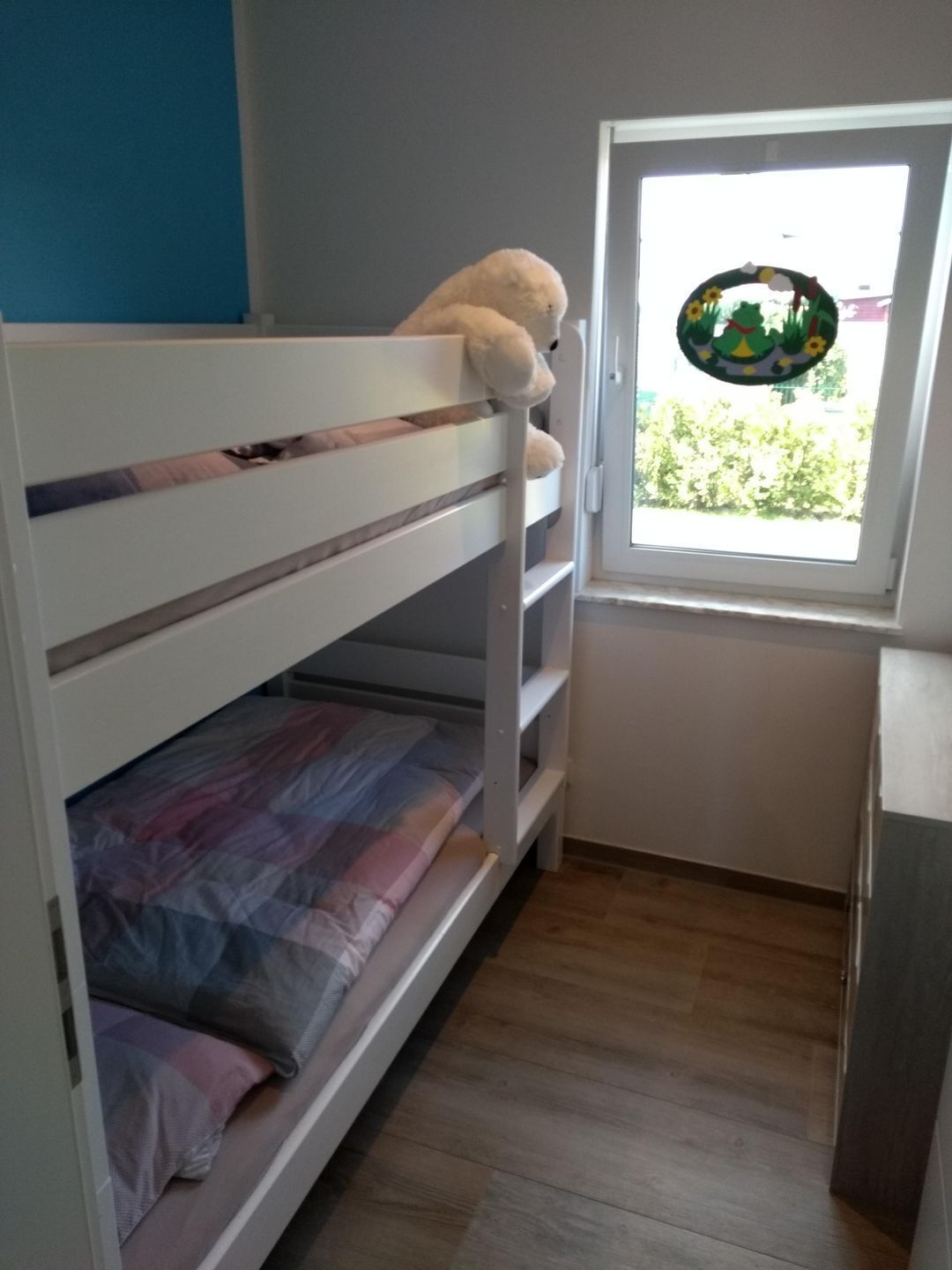 Ein Stockbett mit Fenster, einem kleinen Tisch und einer Tür.