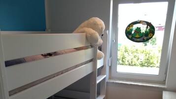 Ein Stockbett mit Fenster, einem kleinen Tisch und einer Tür.