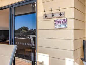 A house with a 'Parents for Sale' sign, a sliding glass door, and outdoor seating. - Beachfront Apartment in Kingscliff (Kingscliff)