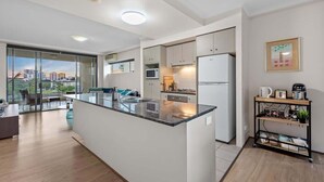 A modern kitchen with a central island, built-in appliances, and a city view. - Superb! 2Bed, 2Bath, 1Car, VIEWS ~ CBD (Brisbane City)