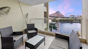A balcony with wicker furniture, a view of a bridge, and a body of water. - Superb! 2Bed, 2Bath, 1Car, VIEWS ~ CBD (Brisbane City)