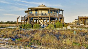 A multi-level wooden structure with a balcony, situated on stilts in a natural landscape. - The Good Life · Ultimate Gulf Shores Getaway: Hot Tub, RV Pad, Fire-Pit & Beach (Gulf Shores)