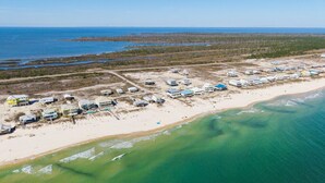 An aerial view of a coastal area with buildings near the beach and a large body of water. - The Good Life · Ultimate Gulf Shores Getaway: Hot Tub, RV Pad, Fire-Pit & Beach (Gulf Shores)