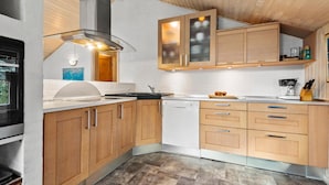 Una cocina moderna con armarios de madera, horno integrado y lavavajillas.