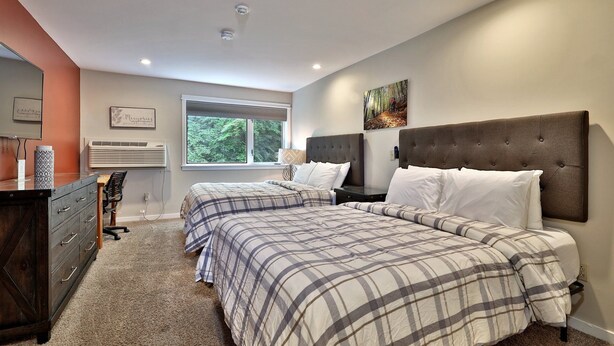 A bedroom with two beds, a dresser, a desk, and a window with a view of trees. - Charming Killington Studio w/ Pool. Bus Route. Ski Rental Deals! - Killington Center Suites 131 (Killington)