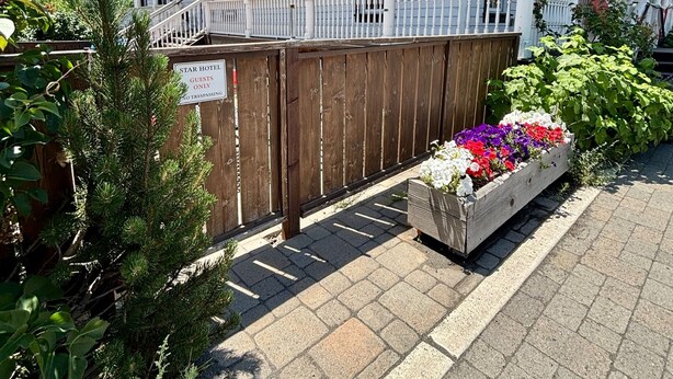 A two-story building with a covered porch and a wooden fence. - Tahoe Star Hotel (Truckee)