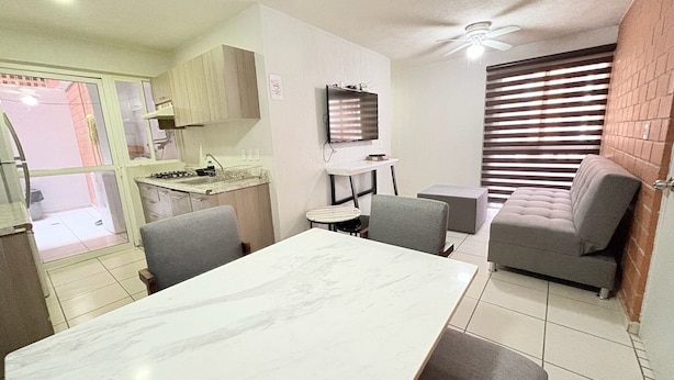 A compact kitchen with a dining area, a small table, and a sofa. -  Torre Federacion 201 Zona Centro Guadalajara (Guadalajara)