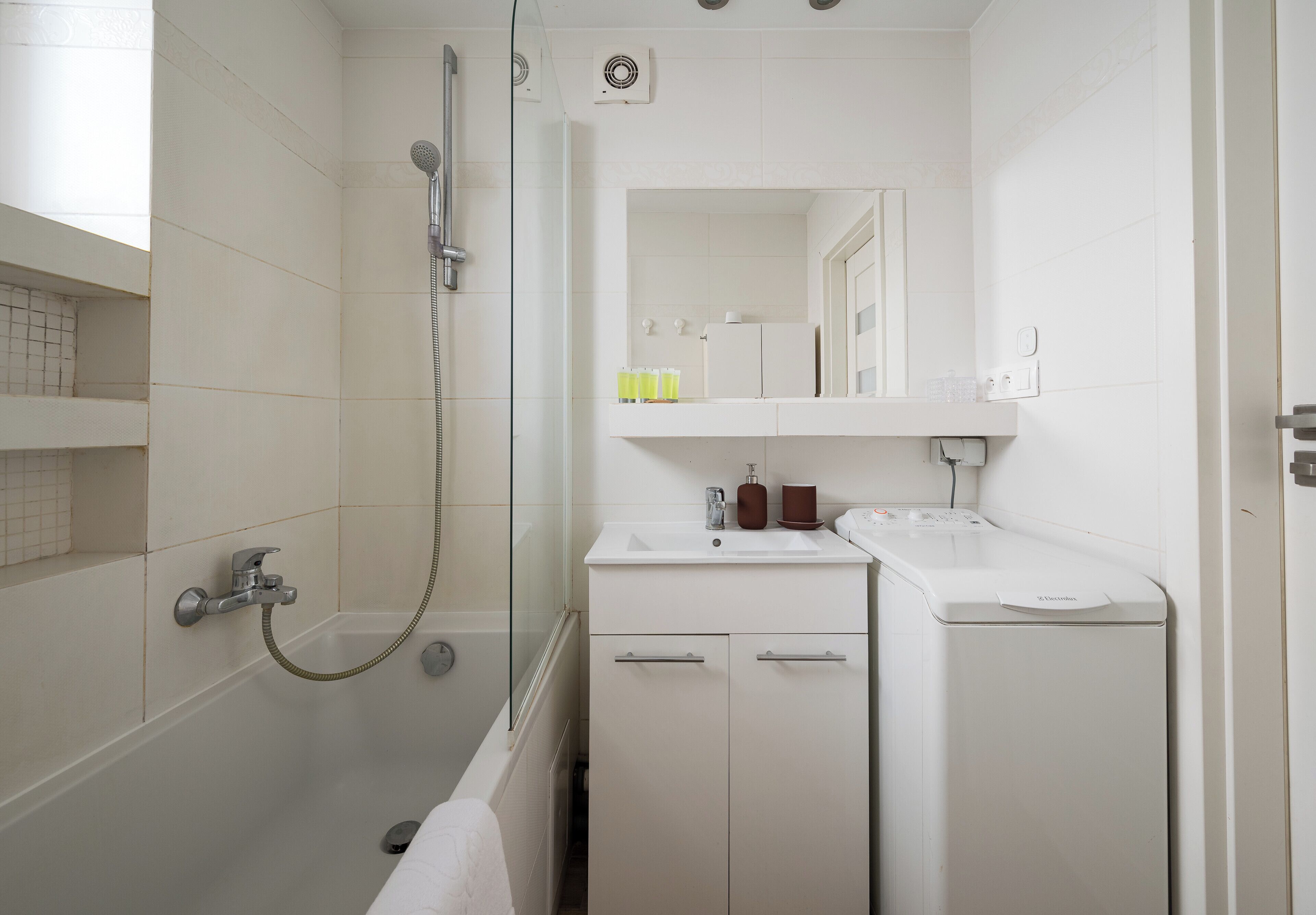A modern bathroom with a shower, a sink, and a toilet.