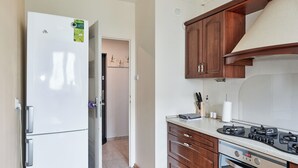 A kitchen with a white refrigerator, wooden cabinets, a gas stove, and a microwave.
