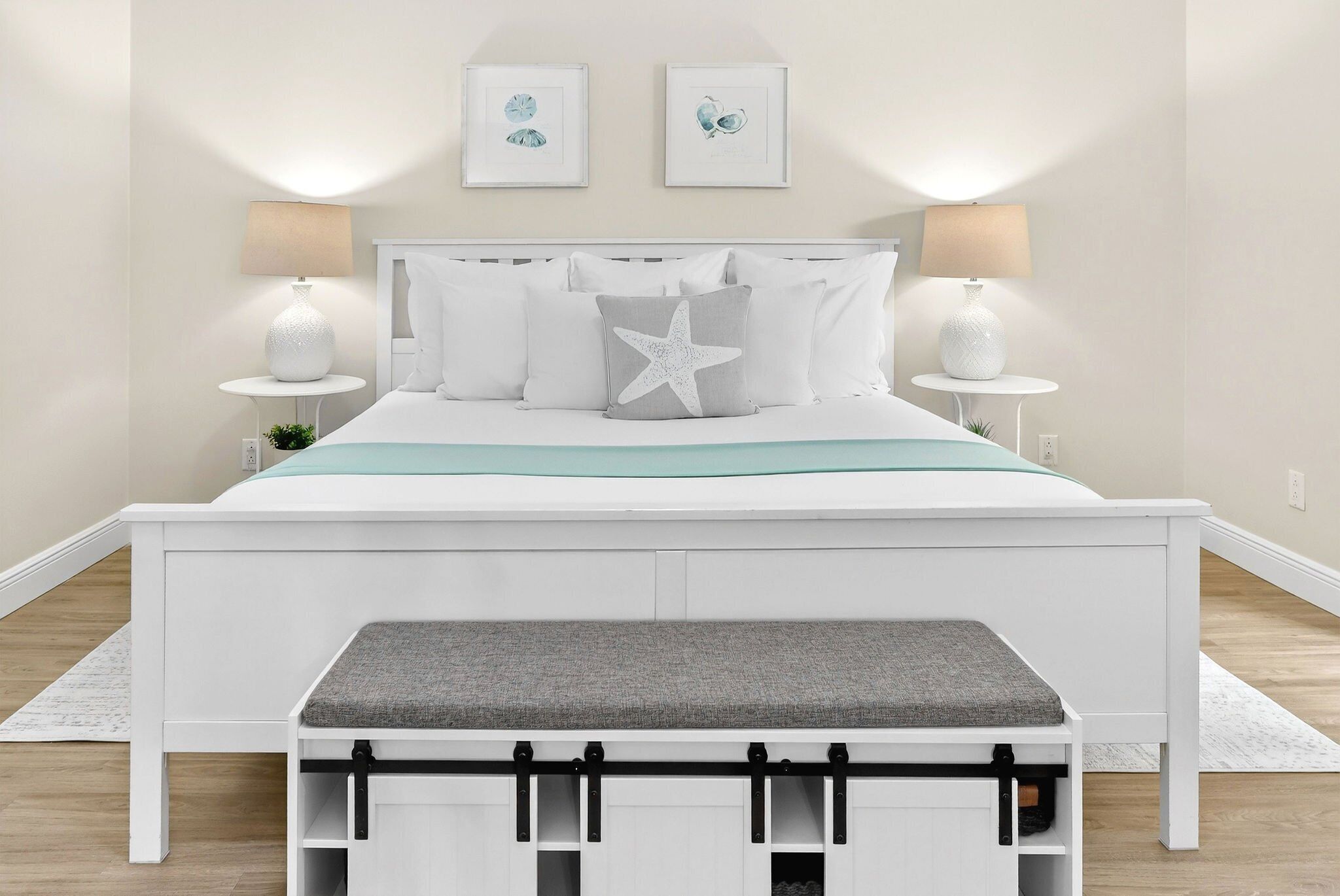 A neatly arranged bedroom with a bed, bedside tables, and a bench.