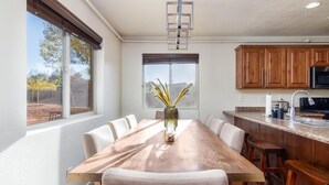 Une cuisine moderne avec des meubles en bois, un évier en acier inoxydable et une grande fenêtre offrant une vue sur l’extérieur.