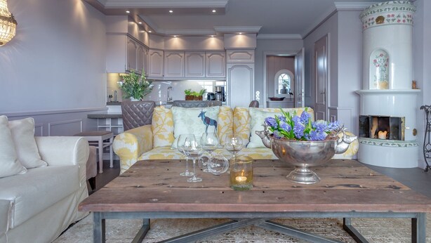 A dining area with a wooden table, a sofa, and a fireplace. - Weetstich - Willkommen im Weetstich in Archsum (Archsum)
