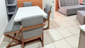 A compact living space with a dining table and chairs, a grey sofa, and a brick accent wall. - Torre Federacion 602 Zona Centro Guadalajara (Guadalajara)