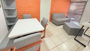 A compact living space with a dining table, grey sofa, and a small coffee table. - Torre Federacion 602 Zona Centro Guadalajara (Guadalajara)