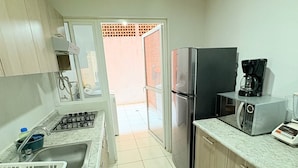 A kitchen with a refrigerator, microwave, coffee maker, and a sink. - Torre Federacion 602 Zona Centro Guadalajara (Guadalajara)