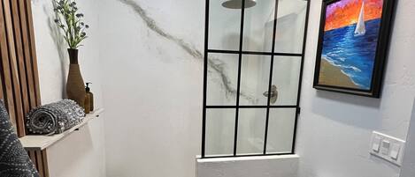 A compact bathroom with a shower, toilet, and a small sink area.