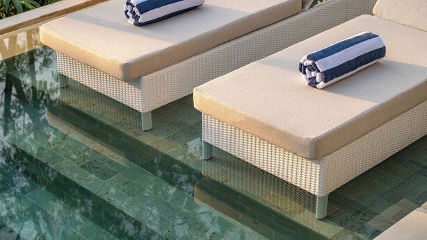 Dos sillones con toallas, situados junto a una piscina.