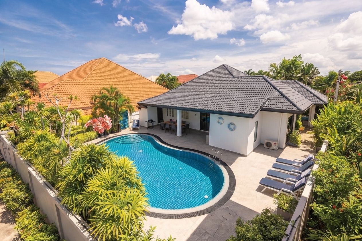 Ein Wohnhaus mit Swimmingpool, überdachter Terrasse und einem kleinen Haus mit Ziegeldach.