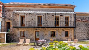 A two-story stone building with a balcony, outdoor seating, and a garden area. - Amazing home in Privas with sauna (Privas)