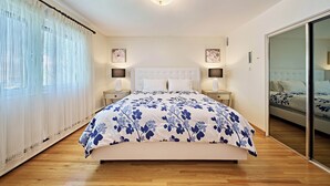 Ein Schlafzimmer mit einem Bett, Nachttischen und einem großen Spiegel.