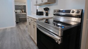 Een moderne keuken met roestvrijstalen apparatuur, lichtblauwe muren en een houten vloer.