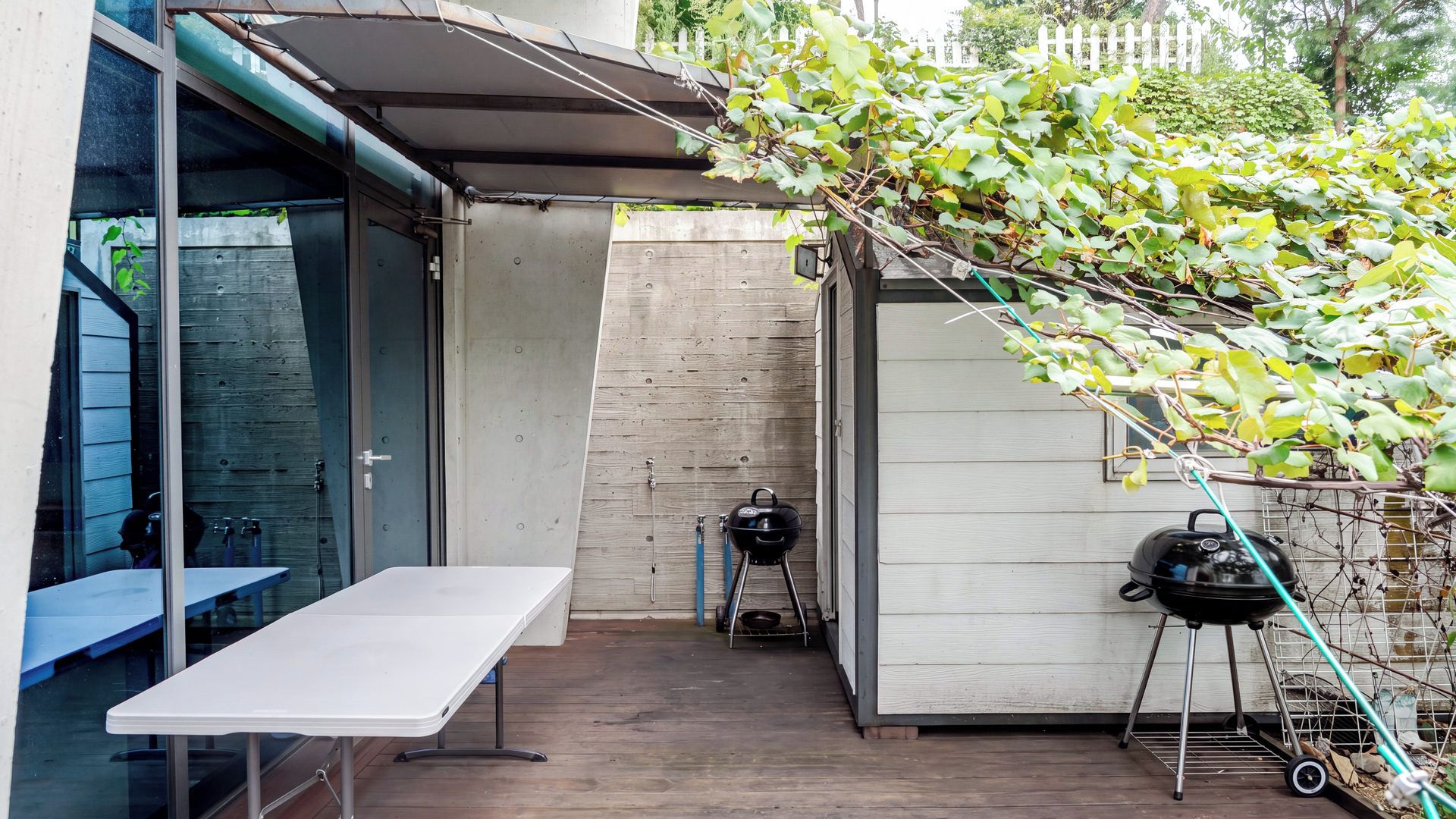 A patio area with a table, a barbecue grill, and a covered seating area.