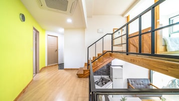 Un interior moderno con una escalera, una zona de cocina y un espacio de estar con vistas.