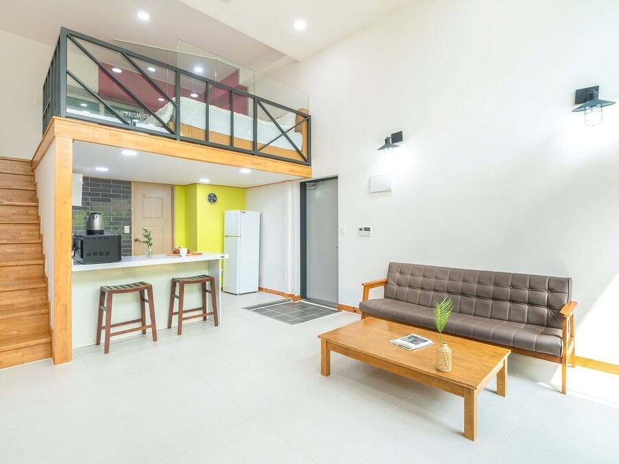 A modern apartment with a kitchen, dining area, and a living room with a sofa and coffee table.