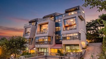 Un hotel de varios pisos con balcones, ventanas amplias e iluminación exterior.
