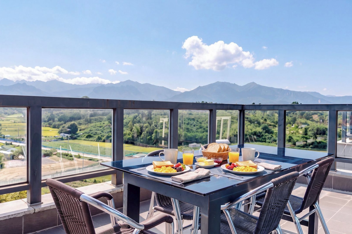 Une table à manger avec des aliments pour le petit-déjeuner et une vue sur les montagnes.