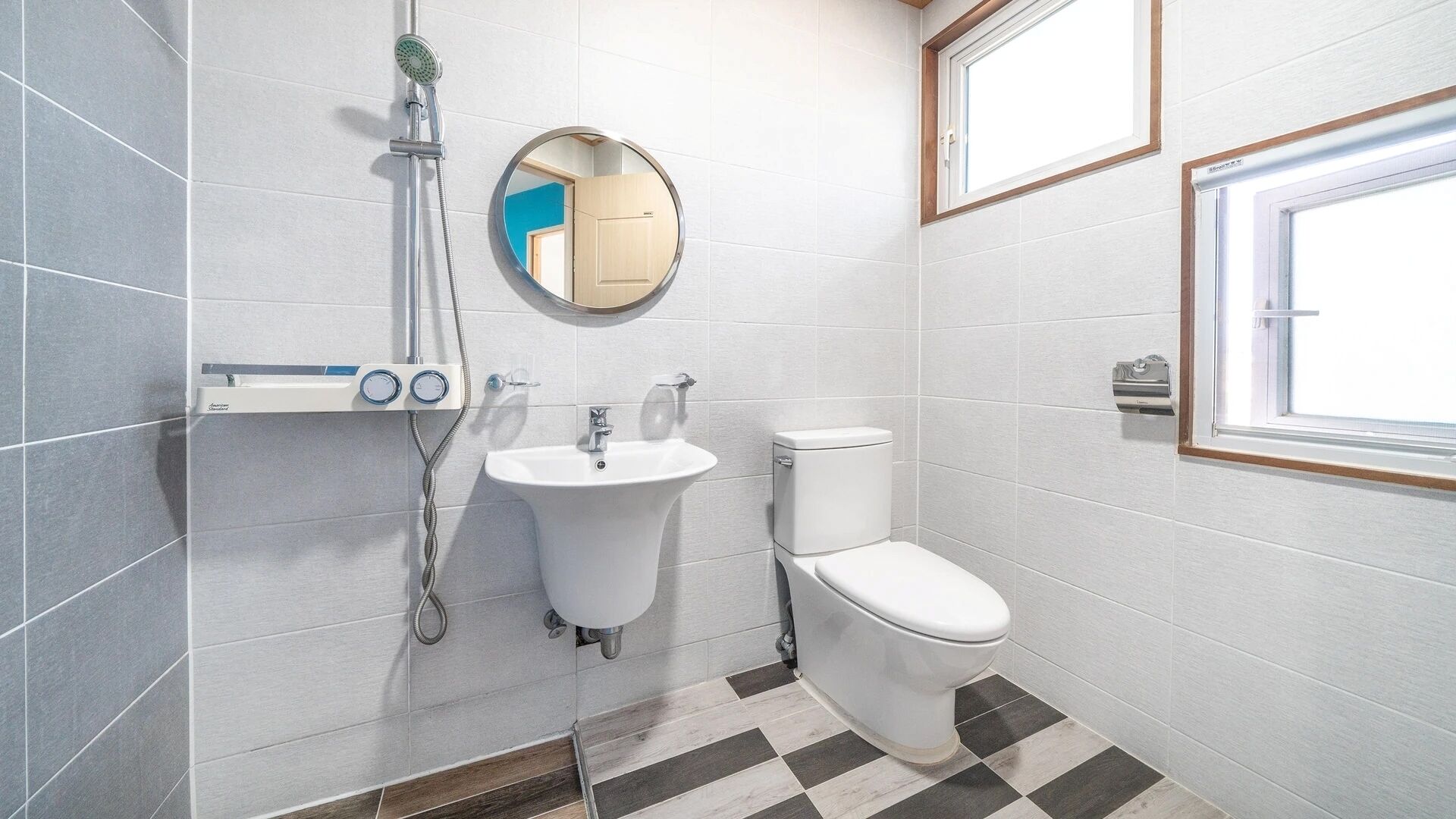 Un baño moderno con ducha, lavamanos, inodoro y ventana.