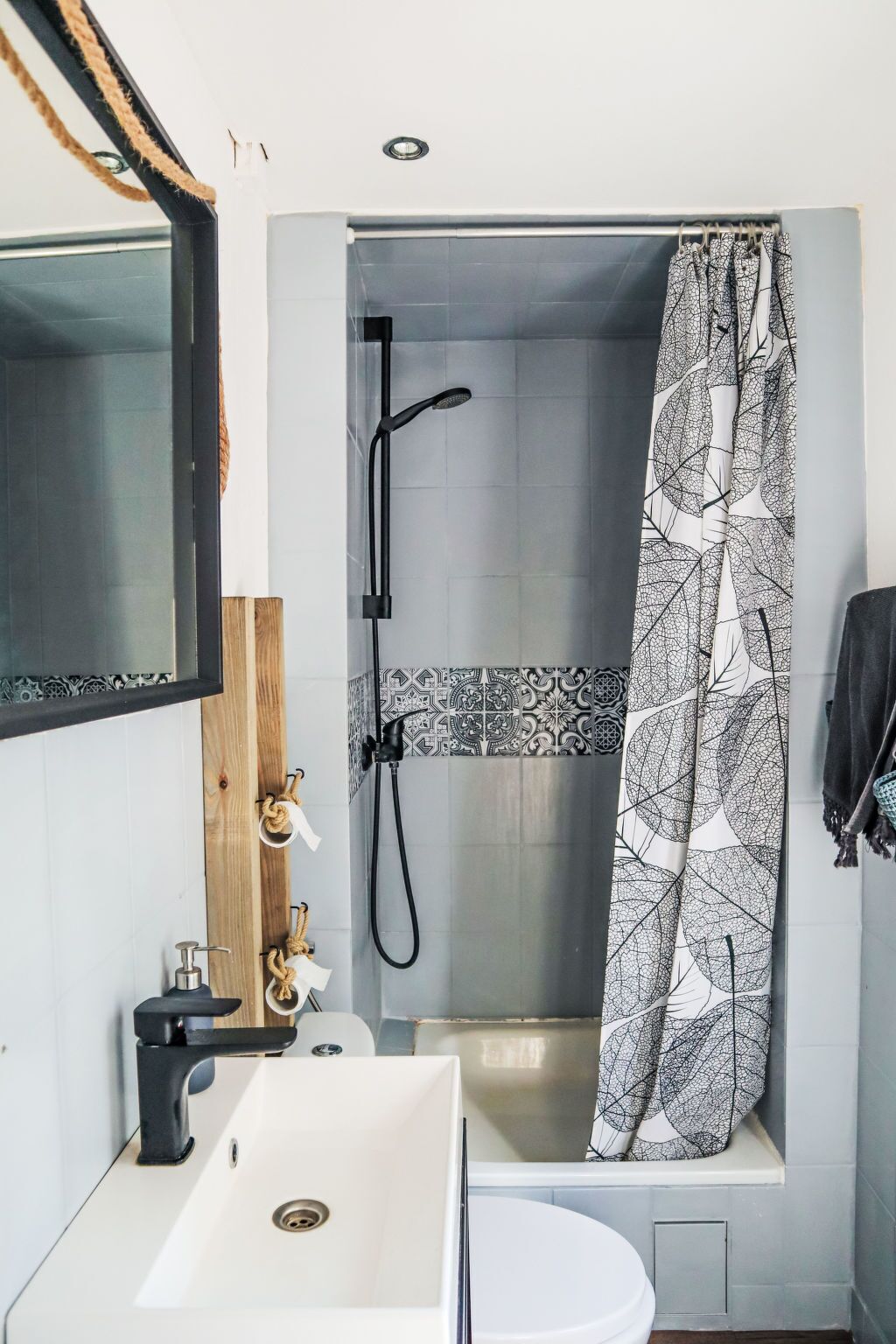 Ein Badezimmer mit Dusche, Waschbecken und Spiegel.