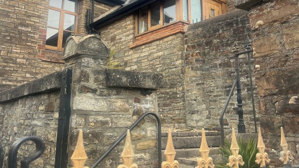 A stone building with a steep roof, wooden windows, and a stone staircase with wrought iron railings. - Barnstaple - Apartment- Sleeps 2 - Parking (Barnstaple)