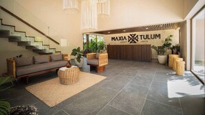 A spacious lobby with a modern staircase, comfortable seating, and a large reception desk. - Tulum Getaway+Pool+Office Area+Gym (Tulum)