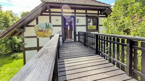 A traditional building with a wooden deck leading to a door marked with the number 221.